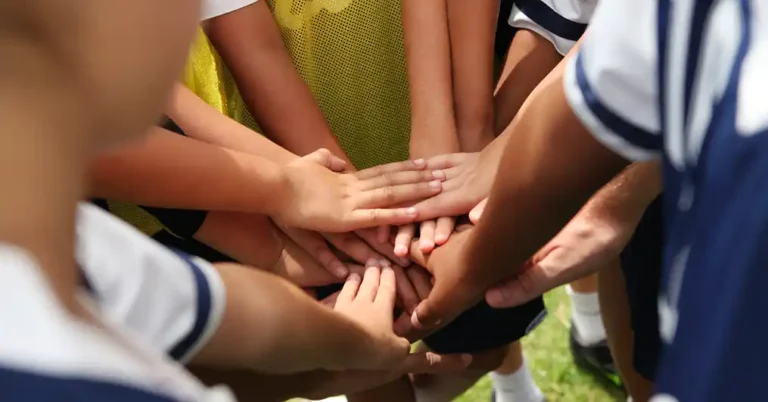 Team with hands on top of each other.