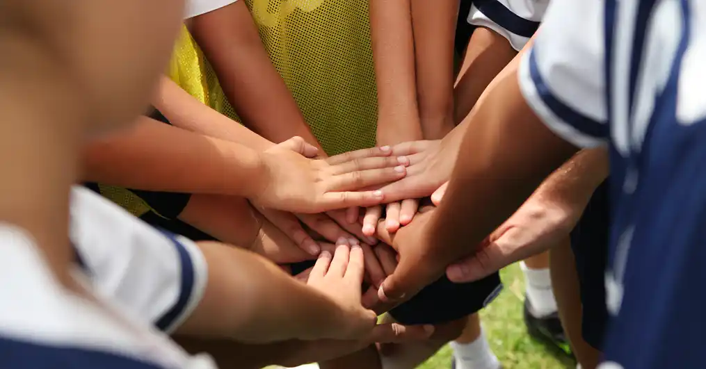 Team with hands on top of each other.